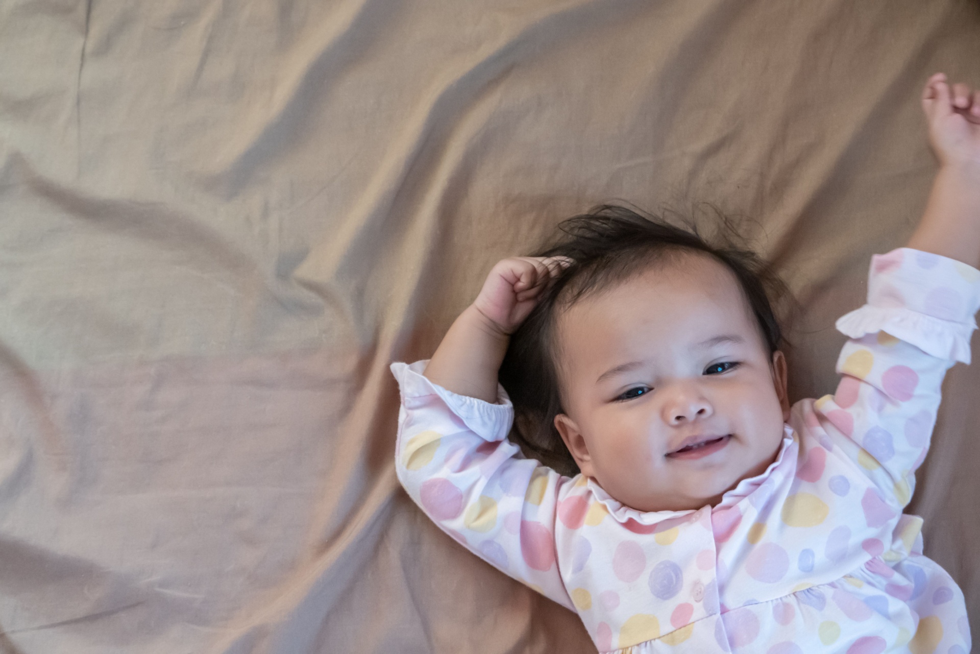 Bebé en pijama con los brazos estirazados